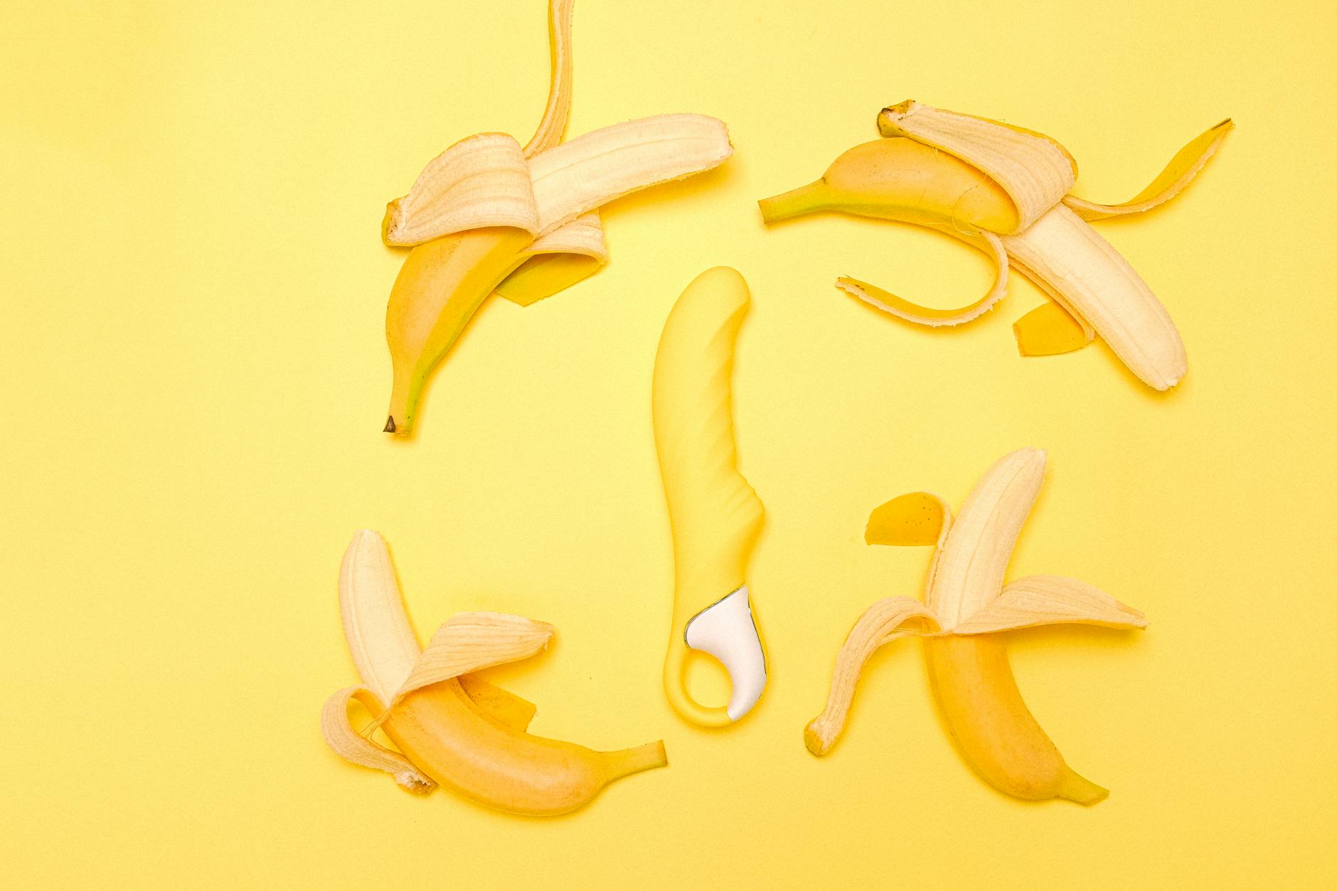 Yellow silicone lemon vibrator on soft background with fresh lemons