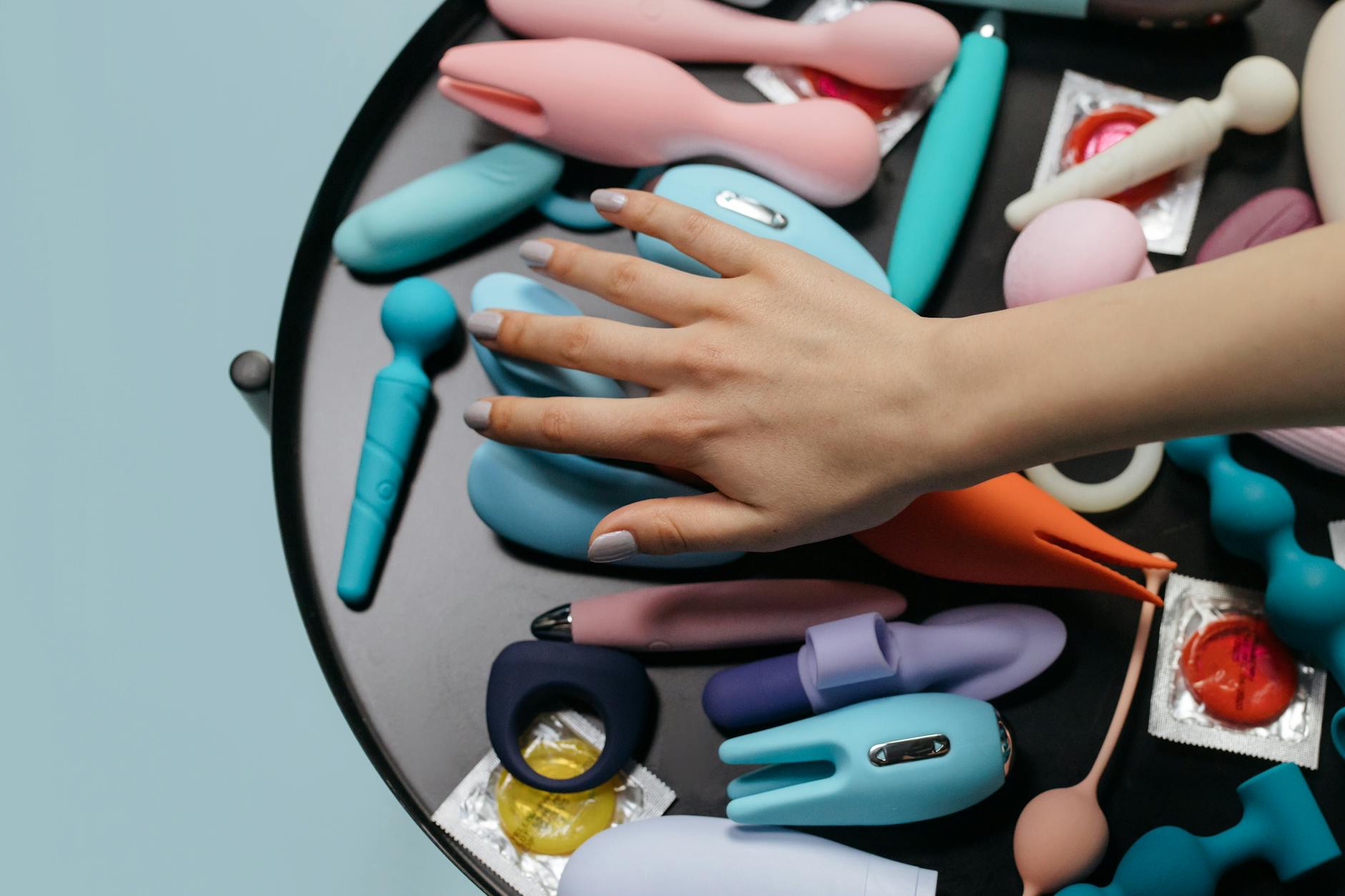 Bright arrangement of colorful pleasure tools and abstract objects on a vibrant yellow background